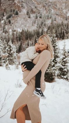 a woman holding a baby in the snow