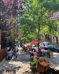 people are sitting at tables on the sidewalk