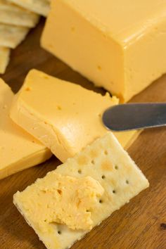 crackers and cheese on a cutting board with a knife