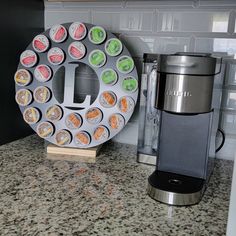 a coffee maker sitting on top of a counter next to a plate with donuts