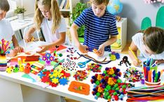 three children are working on crafts at the table