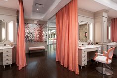 an orange drapes are hanging from the ceiling in this bedroom with two white desks and chairs