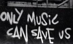 black and white photograph of graffiti on a wall with the words only music can save us