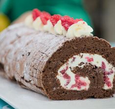 a chocolate roll with cream and raspberries on it