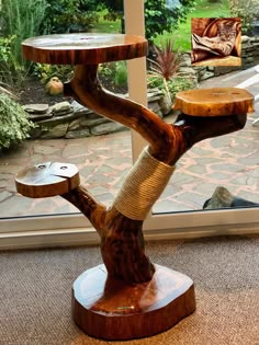 a wooden table with a bird feeder on it's side in front of a window