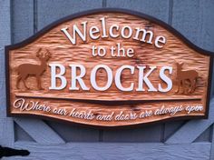 a wooden welcome sign with deer on it