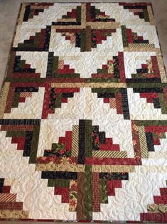 a quilted table topper with red, green and white designs on it's edges