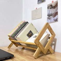 a laptop computer sitting on top of a wooden table next to a stack of books