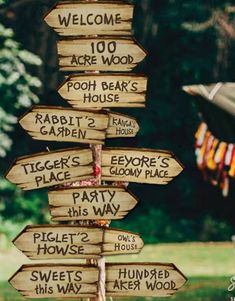 a wooden sign pointing to various locations in the woods with words written on it that read, welcome are wood, poor bear's garden, rabbit's party,