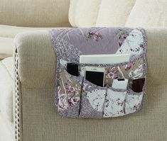 a purse is sitting on the back of a couch with cell phones and other items in it