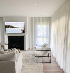 a living room filled with furniture and a flat screen tv mounted on the wall above a fireplace