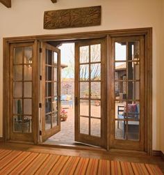 an open wooden door with glass panes on the outside and wood floors in front