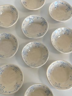 nine blue and white bowls sitting on top of a table