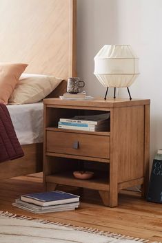 a bed with a wooden headboard and night stand on top of it next to a nightstand