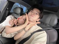 a man and woman sitting in the back seat of a car with their arms around each other