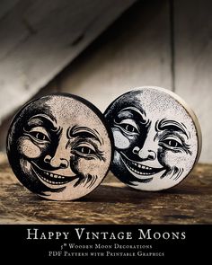 two black and white moon magnets on top of a wooden table with the words happy vintage moon