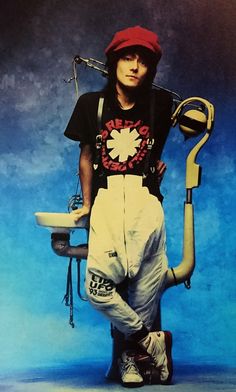 a man is sitting on a toilet with his legs up and holding a pipe in front of him