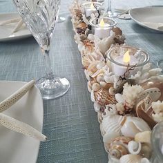 the table is set with candles and seashells