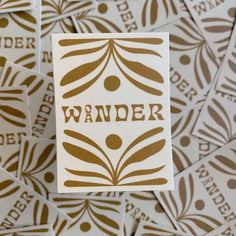 a pile of brown and white stickers with the word wander on them in large letters