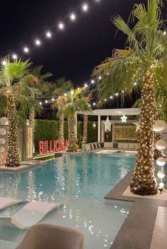 an indoor swimming pool decorated with lights and palm trees