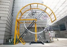 several bicycles are mounted to the side of a building with metal bars and yellow frames