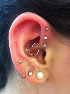 a woman's ear with three piercings on it