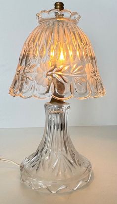 a glass table lamp with a light on it