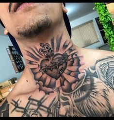 a man with a cross and heart tattoo on his chest