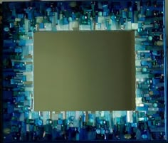 a mirror that is sitting on top of a table with blue and green glass tiles