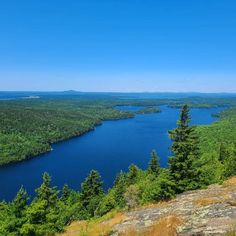 a lake surrounded by trees on top of a hill