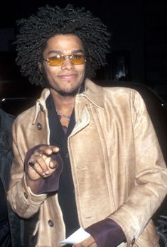 a man in a tan jacket and sunglasses