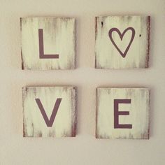 three wooden blocks with the word love written on them in white paint and black ink