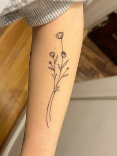 a woman's arm with a flower tattoo on it