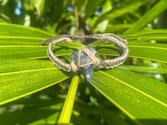 a bracelet is sitting on top of a leaf