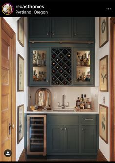 a kitchen with green cabinets and wine bottles on the cupboards, along with other items