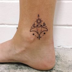 a woman's foot with a small tattoo design on the side of her ankle