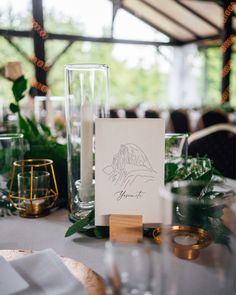 the table is set up with candles and place cards for guests to write their names