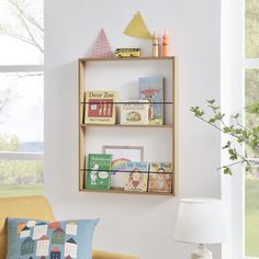 a living room filled with furniture and a book shelf next to a wall mounted window