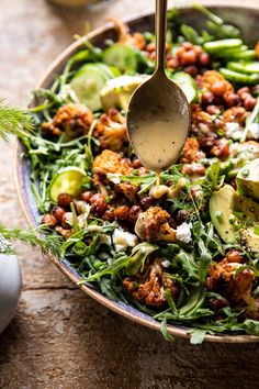 a salad with avocado, lettuce and chickpeas in it