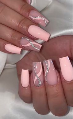 someone is holding their nails with pink and white designs on them, while the other hand holds