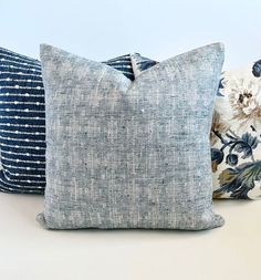 three blue and white pillows sitting next to each other