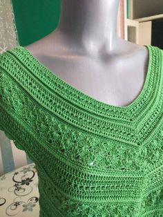 a green crocheted top on a mannequin