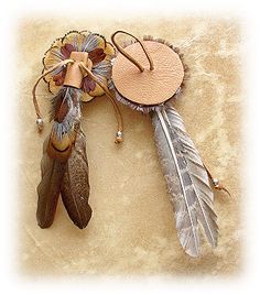 an image of a dream catcher with feathers on it's back and a flower in the middle