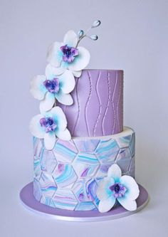 a purple and white cake with flowers on top