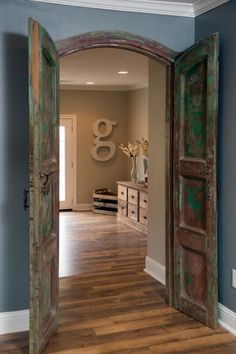 an open door leading into a room with wood floors and blue walls in the background