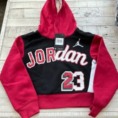 Girls Jordan 23 Hoodie Nwt Red Hooded Top With Letter Print, Red Hooded Tops With Letter Print, Black Hooded School Hoodie, Black Hooded Hoodie For School, Winter School Hoodie Top, Red Drawstring Hood Top For College, Red College Hoodie With Drawstring, Red College Top With Drawstring Hood, Winter School Fleece Tops