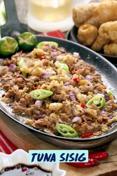 a pan filled with food sitting on top of a wooden table next to other foods