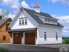 a large white barn with two garages and a steeple on the top floor