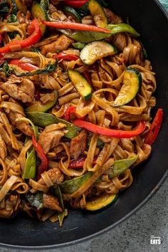 stir fried noodles with vegetables and meat in a skillet