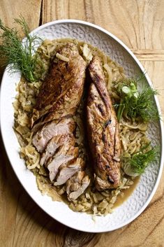 two pieces of meat on top of rice and garnished with fresh dill